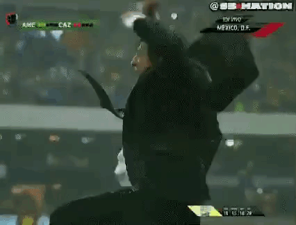 Man In Suit And Tie Holding Head On Soccer Field GIF