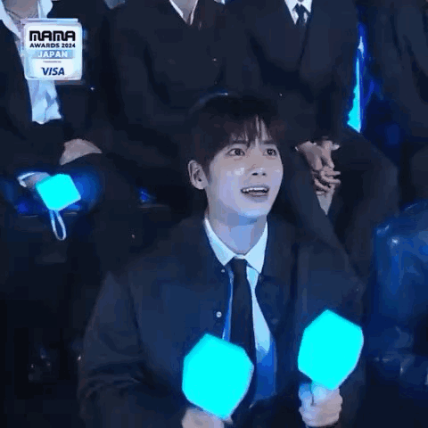 Man in Suit and Tie Holding Light Stick Laughing