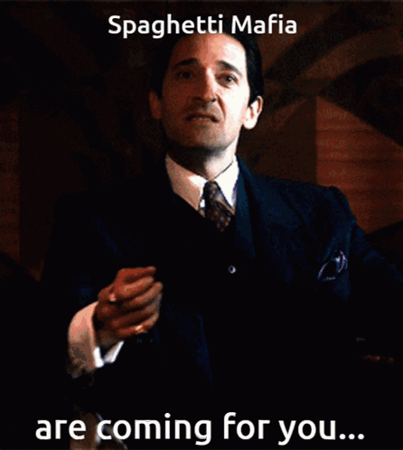 Man in Suit and Tie Holding Paper Saying Spaghetti Mafia Are Coming for You