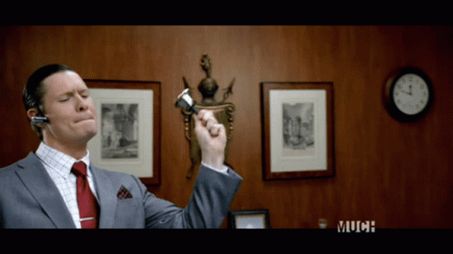 Man In Suit And Tie Holding Pen Near Clock Saying Much GIF
