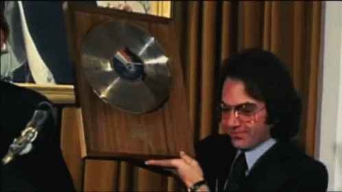 Man In Suit And Tie Holding Plaque With Record GIF