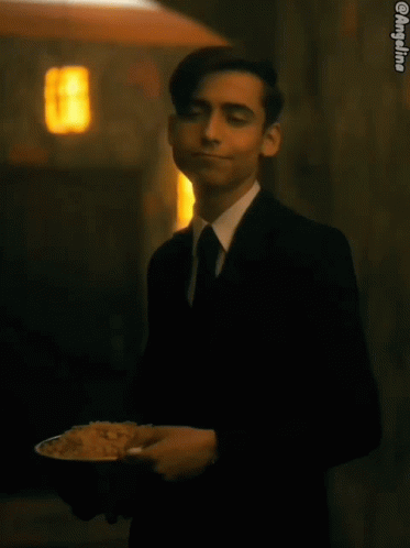 Man in Suit and Tie Holding Plate of Rice Saying Context-Rice