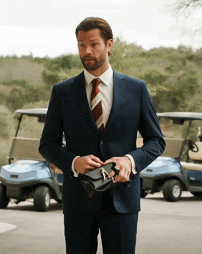 Man In Suit And Tie Holding Purse GIF