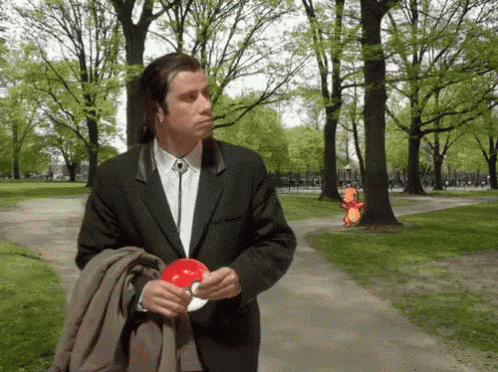 Man In Suit And Tie Holding Red Object GIF