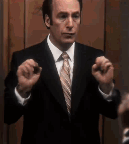 Man in Suit and Tie Holding Something