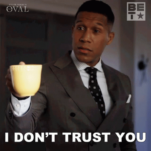 Man in Suit and Tie Holding Yellow Cup Says I Don't Trust You
