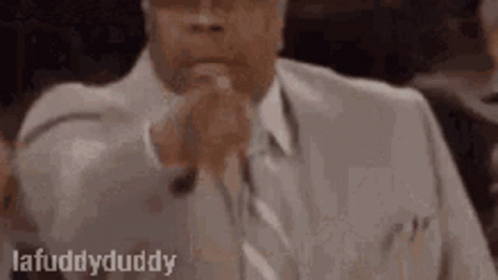 Man In Suit And Tie In Courtroom With Folded Hands GIF