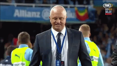 Man in Suit and Tie in Front of Allianz Banner