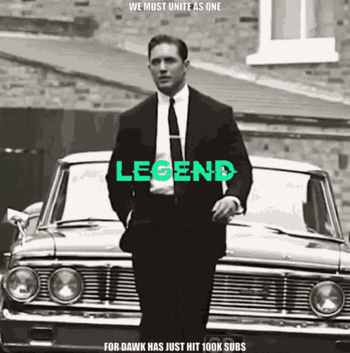 Man In Suit And Tie In Front Of Car With Legend GIF