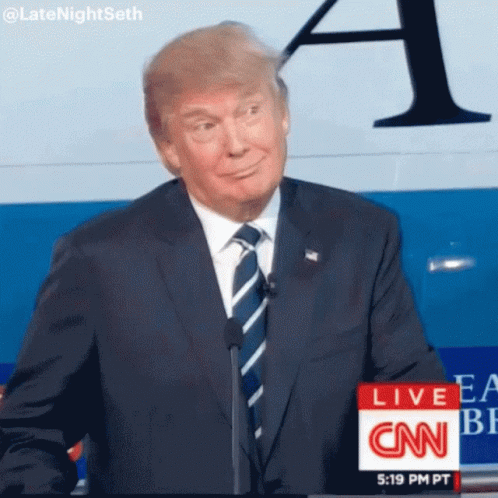 Man in Suit and Tie in Front of CNN Live Sign