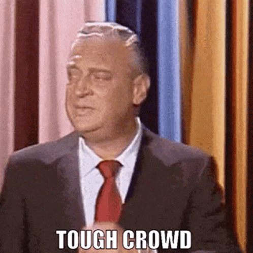 Man In Suit And Tie In Front Of Curtain Tough Crowd GIF