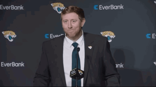 Man In Suit And Tie In Front Of Everbank Wall GIF