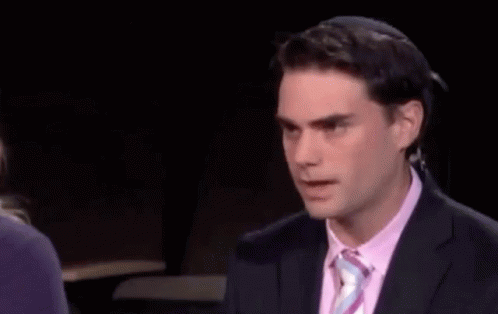 Man In Suit And Tie In Front Of Facts Sign GIF
