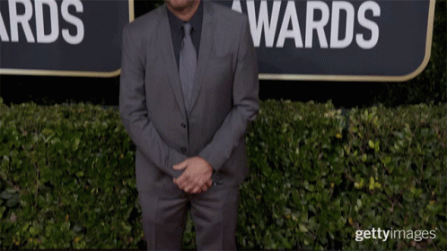 Man in Suit and Tie in Front of Globe Awards Sign