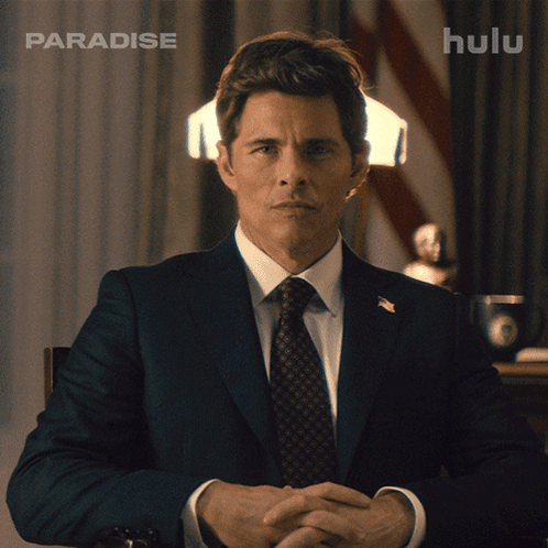 Man In Suit And Tie In Front Of Hulu Ad GIF