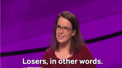 Man in Suit and Tie in Front of Jeopardy Screen