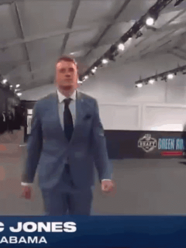 Man in Suit and Tie in Front of Jones Abama Banner