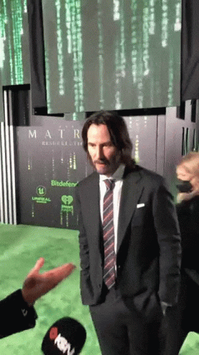 Man in Suit and Tie in Front of Matrix Sign