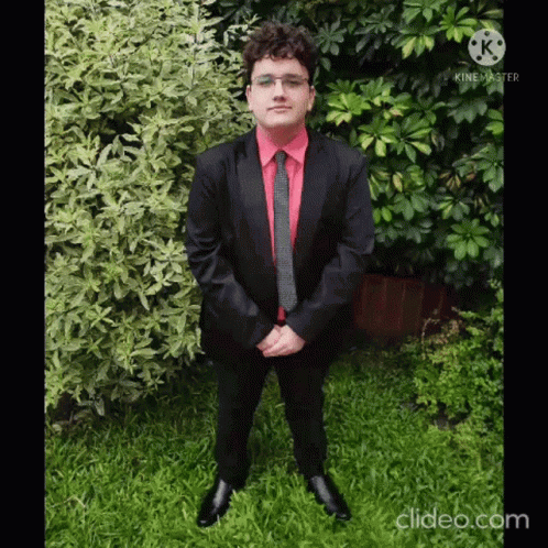 Man in Suit and Tie in Grass with Folded Hands