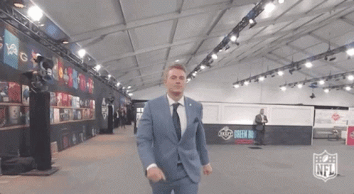 Man in Suit and Tie in Room With NFL Logo
