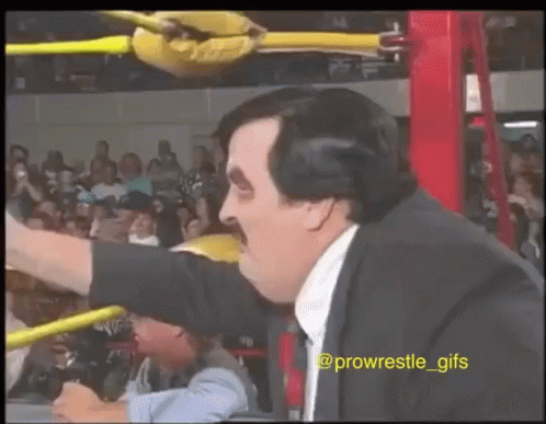 Man In Suit And Tie In Wrestling Ring Arm Outstretched GIF