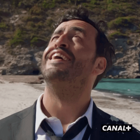 Man In Suit And Tie Laughing At Canal+ GIF