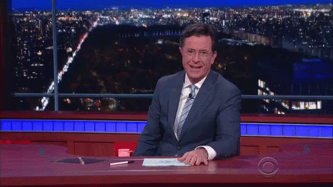 Man in Suit and Tie Laughing at Desk