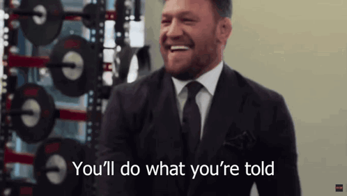 Man in Suit and Tie Laughing Says Youll Do What Youre Told