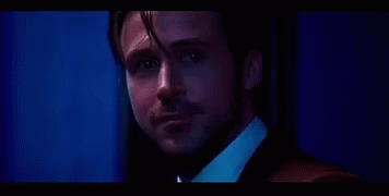 Man In Suit And Tie Looking At Camera Blue Background GIF