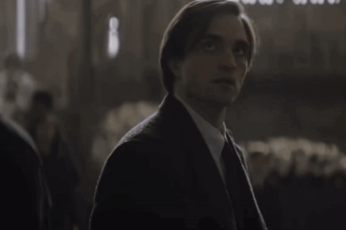 Man in Suit and Tie Looking at Camera in Dark Room