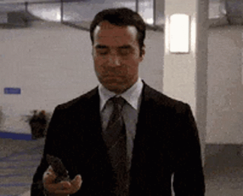Man in Suit and Tie Looking at Phone