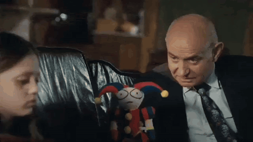 Man in Suit and Tie Next to Girl Holding Stuffed Animal