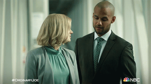 Man in Suit and Tie Next to Woman in Blue