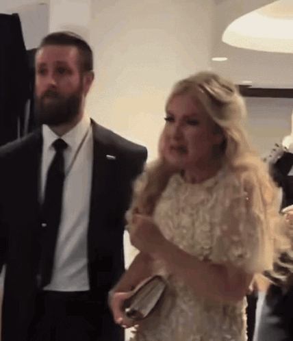 Man In Suit And Tie Next To Woman In Dress GIF