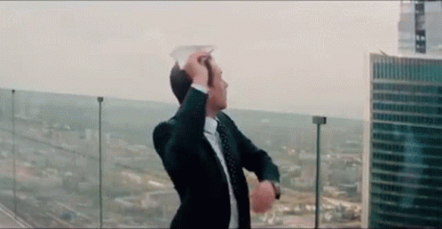 Man in Suit and Tie on Balcony Overlooking City