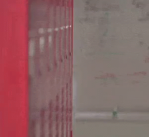 Man in Suit and Tie Peeking from Red Locker