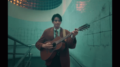 Man in Suit and Tie Playing Guitar