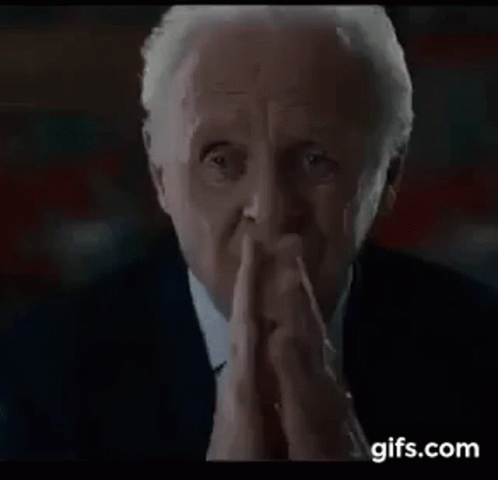 Man in Suit and Tie Praying with Hands Folded