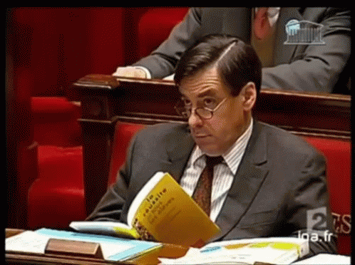 Man In Suit And Tie Reading En Masse GIF