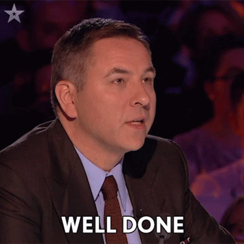 Man in Suit and Tie Says Well Done in Front of Crowd