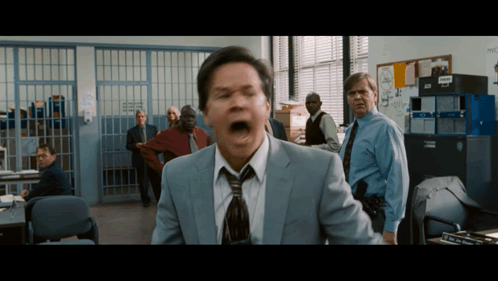 Man in Suit and Tie Screaming in Police Office