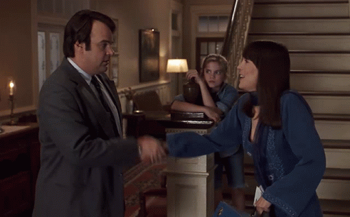 Man in Suit and Tie Shakes Hands with Woman