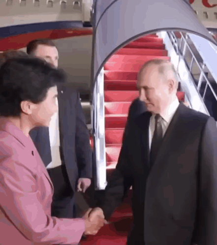 Man In Suit And Tie Shaking Hands With Woman In Pink Suit GIF