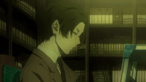 Man in Suit and Tie Sits in Library