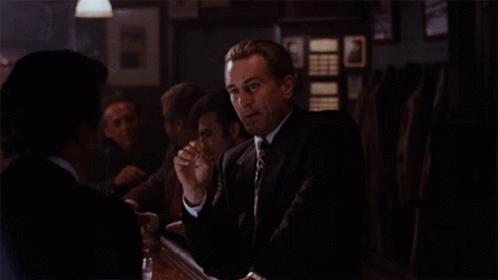 Man In Suit And Tie Sitting At Table GIF