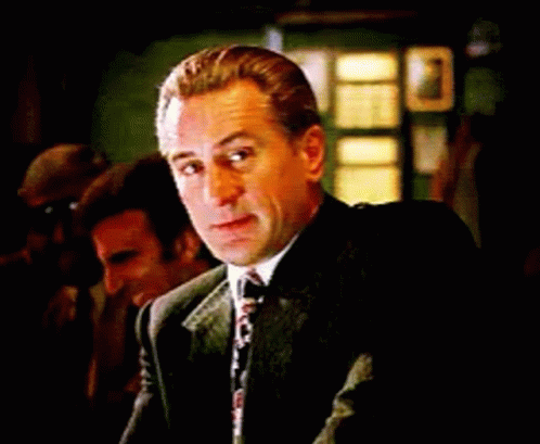 Man in Suit and Tie Sitting at Table Looking at Camera