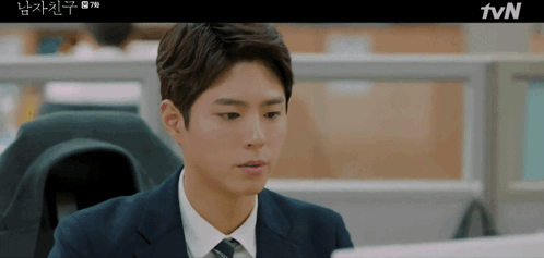 Man In Suit And Tie Sitting At TVN Screen GIF
