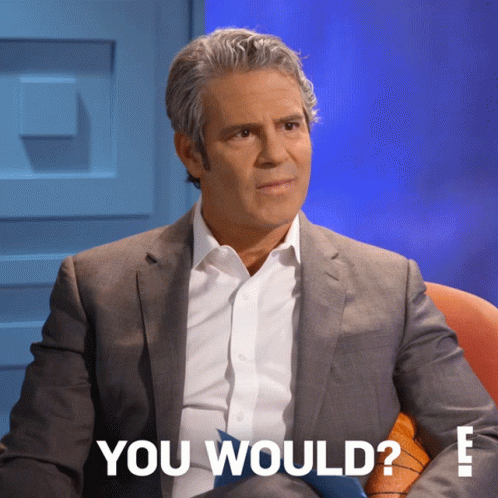 Man in Suit and Tie Sitting in Front of Blue Wall With You Would Text