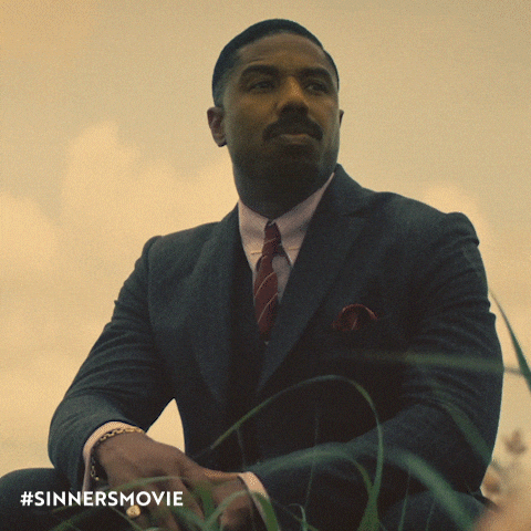Man in Suit and Tie Sitting in Grass with #sinnersmovie