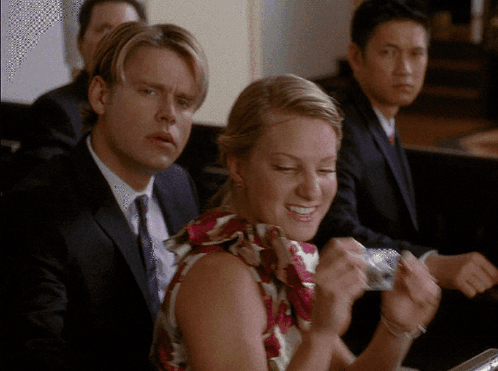 Man in Suit and Tie Sitting Next to Woman